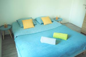 ein blaues Bett mit zwei Kissen und zwei Tischen in der Unterkunft Appartement Cosy 4P - L'Ar Zenith in Saint-Malo
