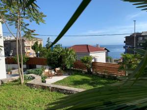 vistas a un patio trasero con un banco y al océano en Kuća za odmor City Oasis en Rijeka