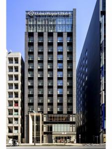 a tall black building with a sign on it at Daiwa Roynet Hotel Tokyo Kyobashi PREMIER in Tokyo