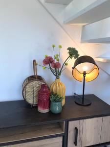 霍勒姆的住宿－de Putter，一张桌子,上面有两瓶花和一盏灯