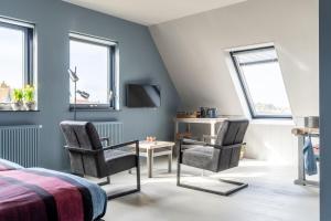 比倫的住宿－B&B Stil de Tijd，一间卧室配有两把椅子、一张桌子和一台电视。