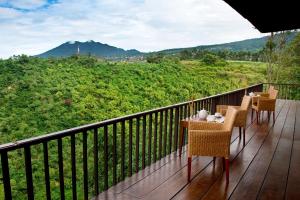 a balcony with a table and chairs and a view at SanGria Resort And Spa in Lembang