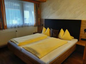 a bedroom with a large bed with yellow sheets and pillows at Apart Birgit in Pfunds