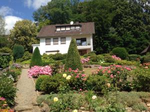 una casa con un jardín con flores delante en Ferienwohnung Waldruhe, en Hessisch Oldendorf