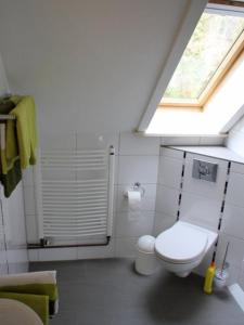 baño con aseo blanco y ventana en Ferienwohnung Waldruhe, en Hessisch Oldendorf