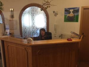 a man sitting at a desk in front of a mirror at Gästehaus RIESENBÜHL in Schluchsee