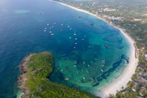 eine Luftansicht auf einen Strand mit Booten im Wasser in der Unterkunft Turtle Bay Beach Club in Watamu