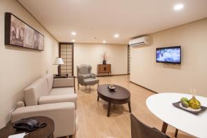 a living room with a couch and a tv on a wall at Jinjiang Inn - Makati in Manila