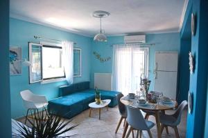 een woonkamer met een blauwe bank en een tafel bij Pogonia Sea View Apartment in Pogoniá