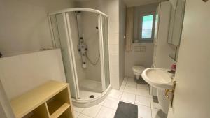 Un baño blanco con ducha y lavabo. en Ferienhaus Goethestrasse, en Bad Harzburg 36 fotos más