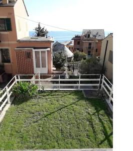 a yard with a white fence in front of a house at Happy House Bogliasco in Bogliasco