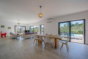 een woonkamer met een houten tafel en stoelen bij Villa calme luxueuse et proche plage saint-cyprien in Lecci