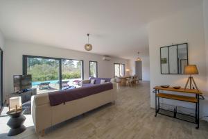 een grote woonkamer met een bank en een tafel bij Villa calme luxueuse et proche plage saint-cyprien in Lecci