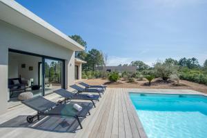 een patio met ligstoelen en een zwembad bij Villa calme luxueuse et proche plage saint-cyprien in Lecci