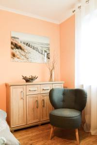 a bedroom with a chair in front of a cabinet at Mieszkanie Nad Morzem in Ustka