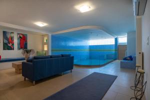 a living room with a blue couch and an aquarium at Villa Luminous in Iraklitsa