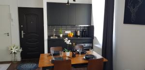 a dining room with a table and a kitchen at Boutique apartman I in Eger