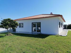 una pequeña casa blanca con un patio verde en Casa Moderna Proxima da Praia en Santa Catarina