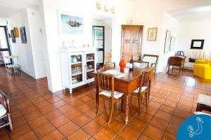 una sala da pranzo con tavolo e sedie di Dimora Caterina - Exclusive villa with sea view a Marongiu