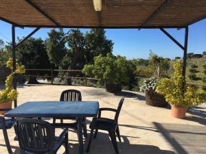 een blauwe tafel en stoelen onder een paviljoen bij Casa Los Ruices in Benajarafe