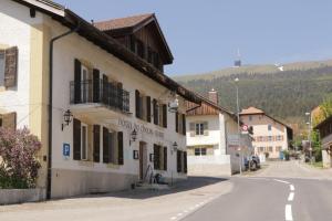 a street in a small town with a building at Hotel du Cheval Blanc in Nods +11 photos
