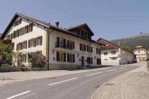 a white building on the side of a street at Hotel du Cheval Blanc in Nods