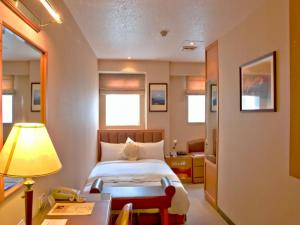a bedroom with a bed and a desk and a lamp at First Hotel in Taipei