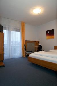 ein Hotelzimmer mit einem Bett und einem Fenster in der Unterkunft Svg Hotel Kalimera in Ludwigshafen am Rhein