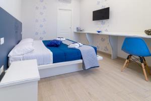 um quarto com uma cama, uma secretária e uma cadeira azul em Nolana '86 em Pompeia