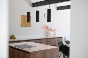 kuchnia z wyspą i czarnymi lampkami w obiekcie Casa Forma w mieście Klimno
