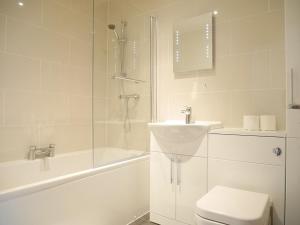 a bathroom with a toilet and a shower and a sink at The Gill Gardens Penthouse, Ulverston - Lake District in Ulverston