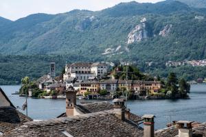 a town on the water with mountains in the background at Locanda di Orta in Orta San Giulio