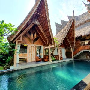 a villa with a pool in front of a house at Premadhan Sanctuary in Canggu