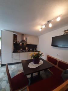 a living room with a table and a kitchen at Apart Maretobi in Pfunds