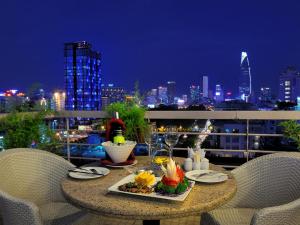 a table with a plate of food on a balcony at night at Elios Hotel in Ho Chi Minh City