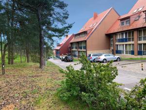 a group of buildings with cars parked in a parking lot at Forest View in Nida