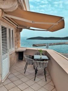 eine Terrasse mit einem Tisch und Stühlen auf dem Balkon in der Unterkunft Apartments Luka, Punta Jurana in Korčula