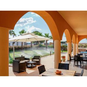 a patio with a table and an umbrella at Hotel Donna Carmela Sede Unica a Sciacca in Sciacca