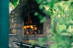 Un horno de piedra con fuego. en Kuća za odmor Andrej, en Perućac