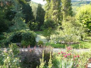 a garden with lots of flowers and a pond at La Pluie de Roses in Giverny +9 photos