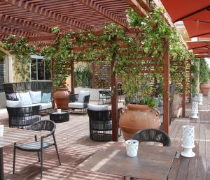 un patio al aire libre con mesas, sillas y una pérgola en Saint Joseph, en Salerno