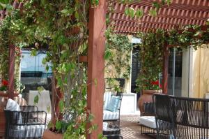 een pergola met planten en stoelen op een patio bij Saint Joseph in Salerno