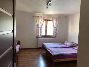 - une chambre avec 2 lits et une fenêtre dans l'établissement Apartmán Tatiana, à Terchová