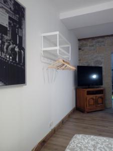 a room with a flat screen tv and a tv stand at Le Gîte du haut in Châtillon-la-Palud