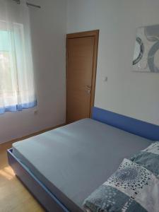 ein kleines Schlafzimmer mit einem Bett und einer Tür in der Unterkunft Vila Jovana in Sutomore