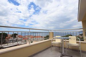 a balcony with a table and chairs on a balcony at Dorijini Dvori in Baška Voda