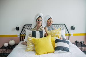 Due donne sono sedute su un letto di Pink Flamingo Boutique Hostel a L'Aia
