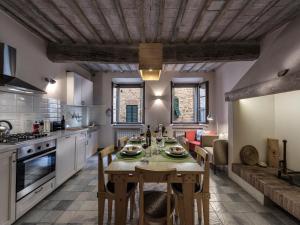 a kitchen with a wooden table in a room at Apartment La Scala 1572 in San Quirico dʼOrcia