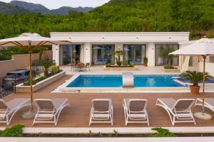 uma villa com piscina e cadeiras e uma casa em Villa Salute em Budva