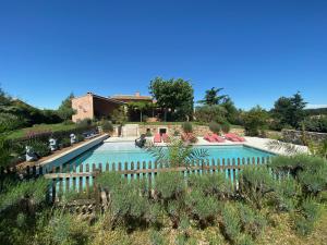 a large swimming pool with a fence around it at Domaine Hestia in Robion en Luberon
